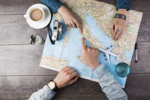 Young couple planning honeymoon vacation trip with map. Top view. Pointing to Europe Rome